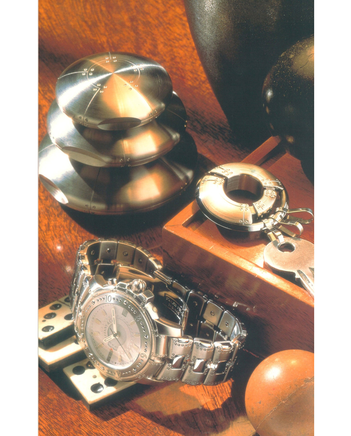 Loring’s 1997 Book: Tiffany's 20th Century: A Portrait of American Style. Perisphere Nesting Boxes in three sizes, Porthole Keychain, and World Time Wristwatch with Stainless Steel Band.